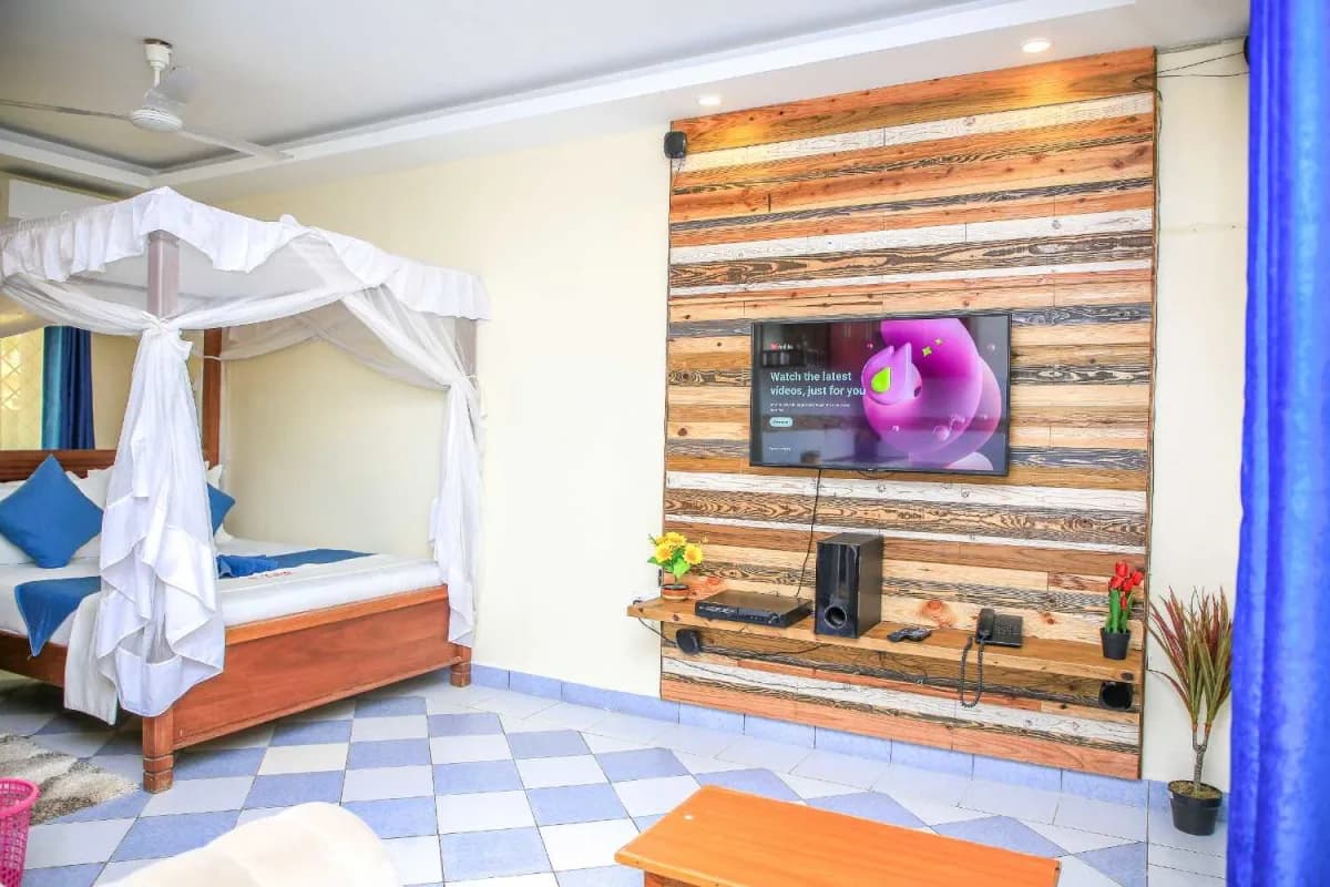 Standard room at Lemach Hotel with a canopy bed and smart TV